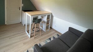 Une pièce comprenant un bureau, une chaise et un canapé.