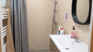Une salle de bain équipée d’une douche, de toilettes, d’un lavabo et d’un porte-serviettes.