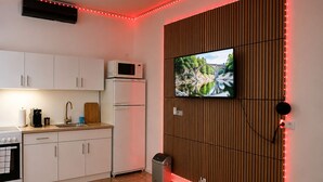 Une cuisine moderne avec des meubles blancs, un four à micro-ondes, une cuisinière et un évier.