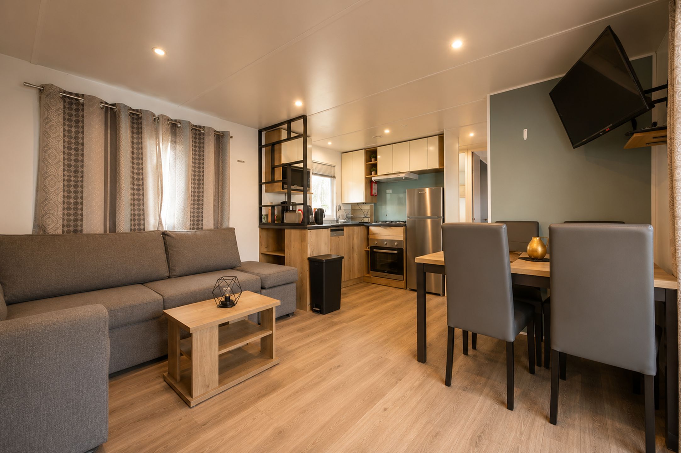 Una sala de estar moderna con un sofá, una mesa de centro y un comedor con sillas y una mesa.