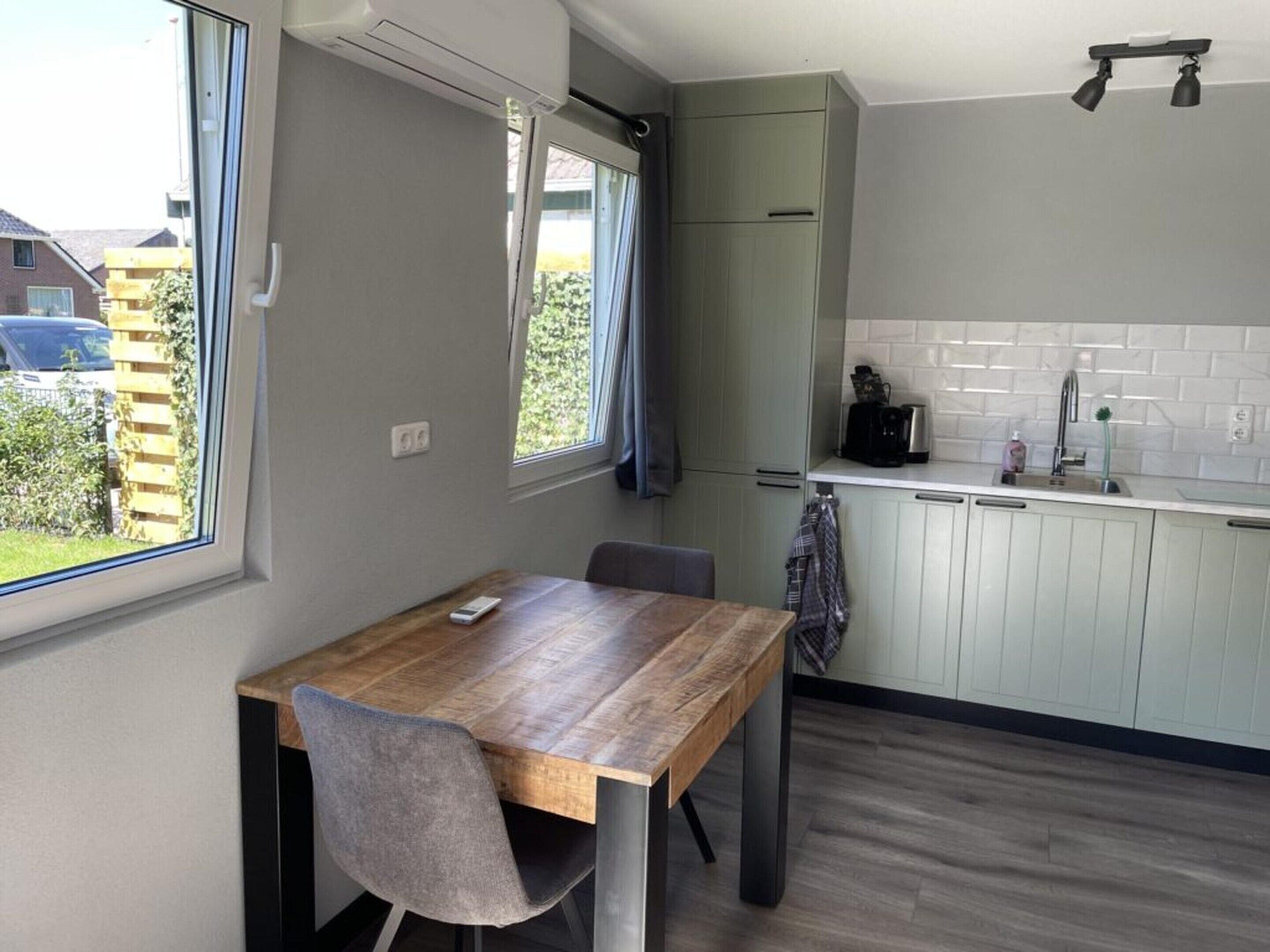 A compact kitchen with a dining table, a window, and a built-in oven.