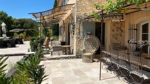 Un edificio de piedra con terraza al aire libre, una pérgola y un letrero que dice 'FANNY'.