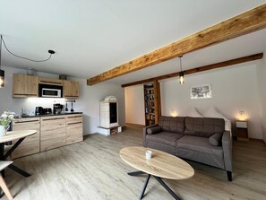 A modern living space with a kitchen, dining area, and seating area. - Neues Appartement Nr. 6 im Lepels Hof (Luetow)