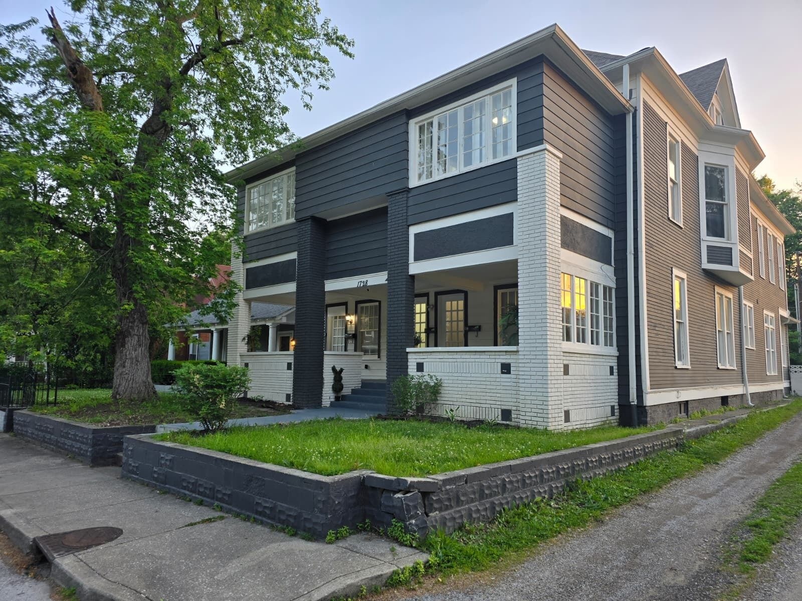 A two-story house with a front porch, a garage, and a well-maintained lawn.