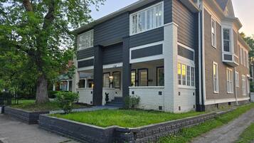 A two-story house with a front porch, a garage, and a well-maintained lawn.