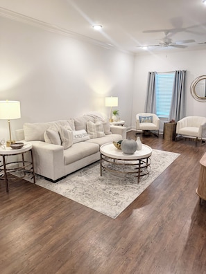 A living room with a sofa, two armchairs, a coffee table, and a floor lamp.