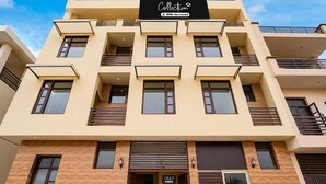A multi-story building with a reception area, balconies, and a sign indicating it is serviced by OYO. - Deluxe Chandigarh Outer (Kharar)
