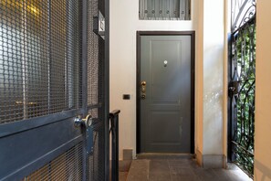 A closed metal gate, a dark door, and a metal gate with a decorative design. - CO99 - Cozy Studio Mauri (Milano)
