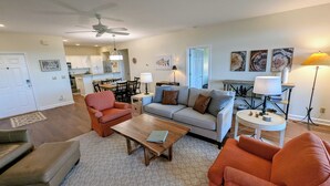 A living room with a sofa, armchairs, a coffee table, a dining table, and a kitchen in the background. - Walk to the slopes!  2BR in The Reserve with iconic Grandfather Mountain views (Sugar Mountain)