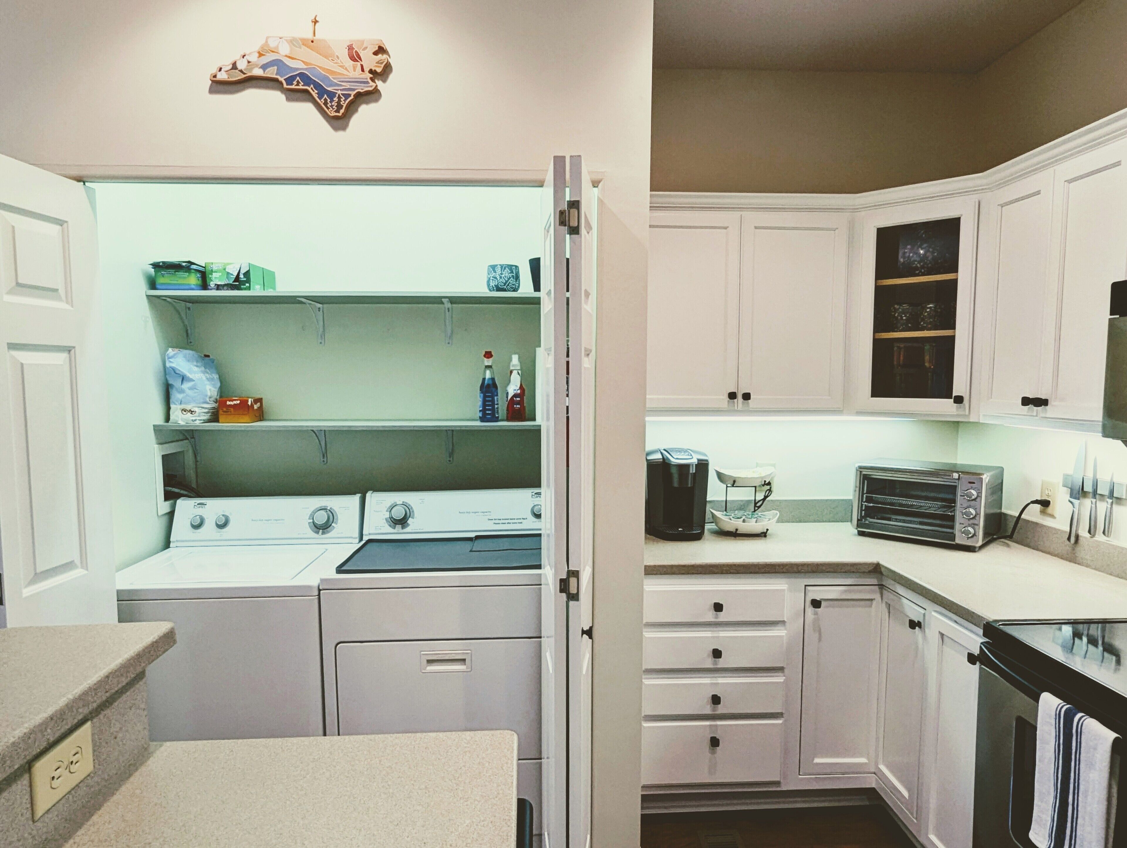 A kitchen with white cabinets, a toaster oven, and a coffee maker.