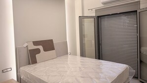 Een moderne slaapkamer met een bed, een kledingkast en een airconditioning.