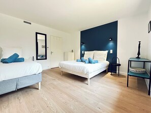 Ein Hotelzimmer mit zwei Betten, einem Spiegel, einer kleinen Kommode und einem Nachttisch.