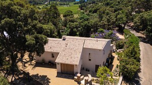 A villa with a tiled roof, surrounded by trees and a view of the sea. - Villa Sarrazine: Sea View & Walk to Beach (La Croix-Valmer)