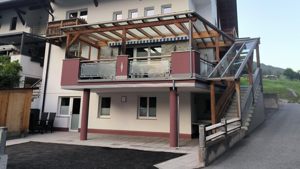 A multi-story building with a covered outdoor area, a staircase, and a view of the surrounding landscape. - Apartment in Strengen With Mountain Views (Strengen)