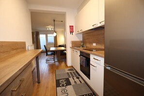 Une cuisine moderne dotée d’un plan de travail en bois, d’un four encastré et d’un réfrigérateur.
