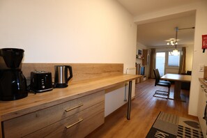 A modern kitchen with wooden countertops, a coffee maker, and a kettle. - Apartment in Strengen With Mountain Views (Strengen)