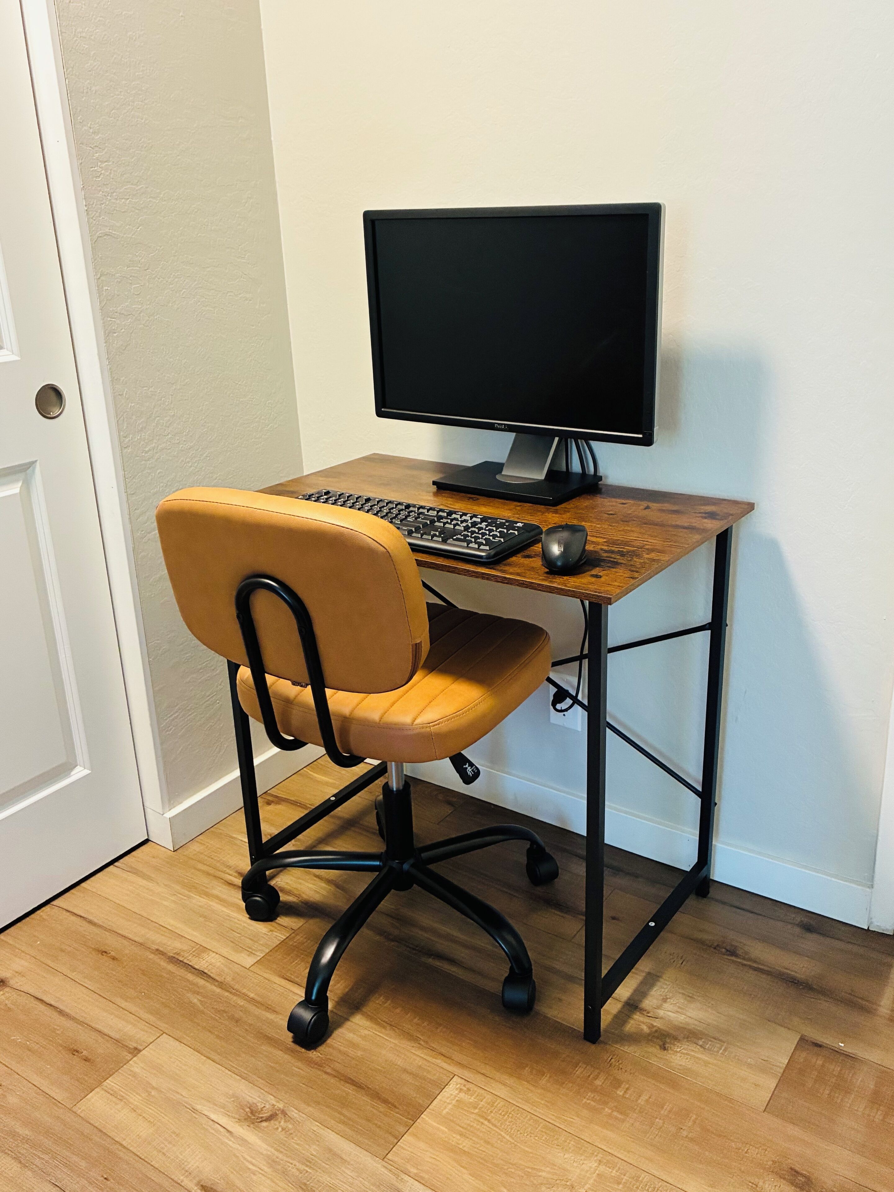 Ein Computertisch mit Bildschirm, Tastatur und Maus.