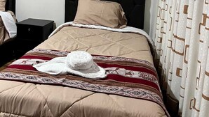 Une chambre d’hôtel avec un lit, une table de chevet et un rideau.