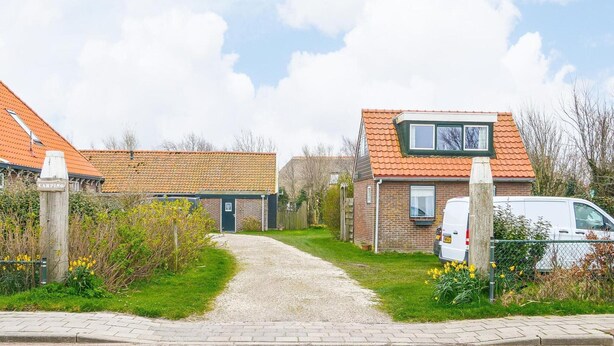 A pathway leading to a row of houses with a brick facade and orange-tiled roofs. - Pet-friendly Home in Callanstoog Near Beach (Callantsoog)