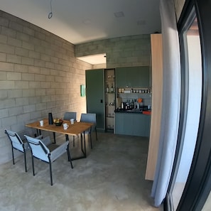 A compact living space with a dining area, kitchenette, and a large window.