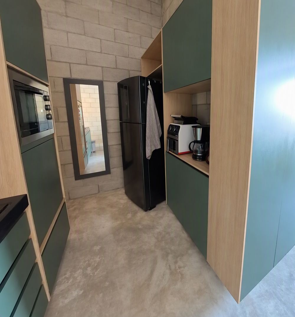 A compact kitchen with a refrigerator, a coffee maker, and a microwave.