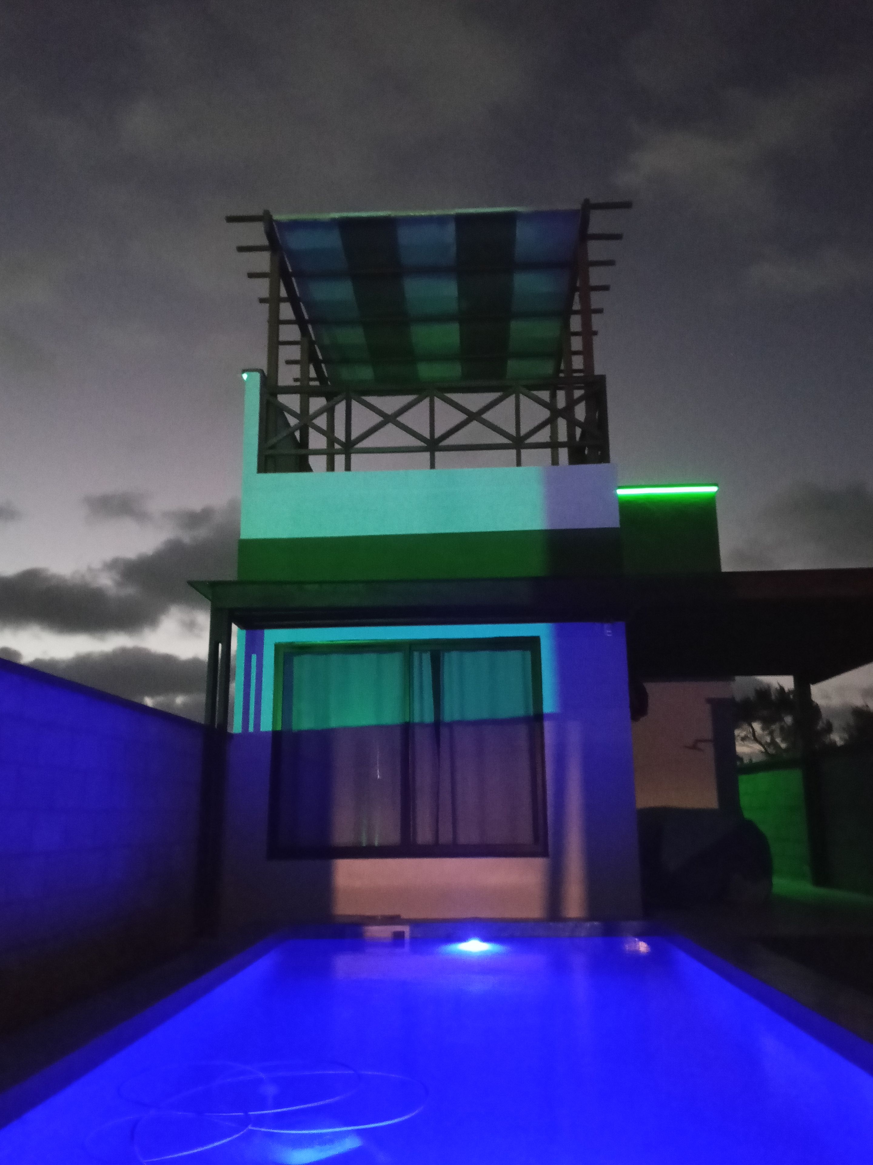 Ein Gebäude mit Pool und überdachtem Bereich mit Blick auf den Himmel.