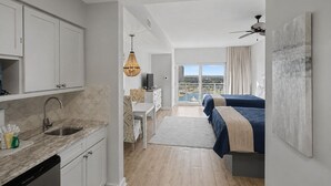 A modern hotel room with a kitchen, a dining area, a bed with a view, and a balcony. - New Listing: Awesome Views Luau SanDestin Resort (Destin)