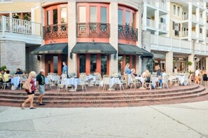 Een restaurant met terras, een gevel van baksteen en een balkon.