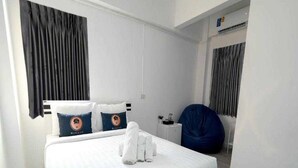 A hotel room with a large bed, a chair, a desk, and a window with curtains. - Trendy Double Retreat by North Pattaya's Coast (Pattaya)