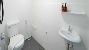 A small, white bathroom with a toilet, sink, and a mirror above the sink. - Trendy Double Retreat by North Pattaya's Coast (Pattaya)