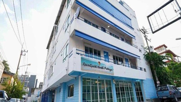 A multi-story building with a sign reading 'RoomQuest North Pattaya.' - Trendy Double Retreat by North Pattaya's Coast (Pattaya)