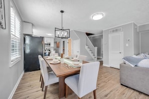 A modern kitchen with a dining area, wooden flooring, and a staircase leading to another level. - Luxury Lakefront Retreat with Private Dock ,Sleeps 16 (Lake Harmony)