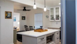 A kitchen with a central island, white cabinets, and a ceiling fan. - Villas House - 10 mins to Cape May, 15 to Wildwood (Lower Township)