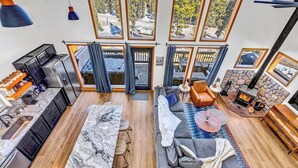 Ein modernes Wohnzimmer mit Küche, Sitzecke und Kamin.