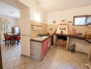 A kitchen with a central island, a fireplace, and a dining area with a table and chairs.