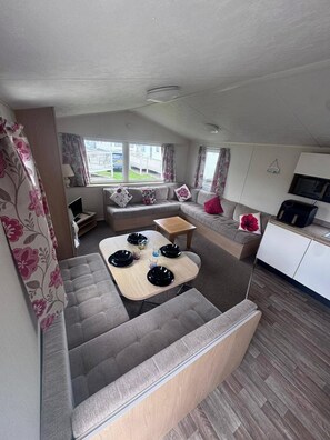 A compact living space with a sofa, a small dining table, and a kitchenette area.