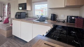 Una cocina compacta con estufa a gas, un lavamanos y una encimera.