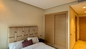 Ett hotellrum med en stor säng, en garderob och en dörr som leder till ett annat rum.