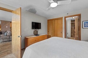 A bedroom with a bed, a dresser, a television, and a wooden wardrobe. - Walk to Dillon Amphitheater and Lake at Marina Place (Dillon)