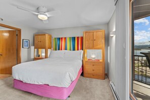 A bedroom with a bed, wooden cabinets, a ceiling fan, and a view of the outdoors. - Walk to Dillon Amphitheater and Lake at Marina Place (Dillon)