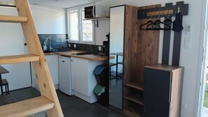 Eine kleine Küche mit Mikrowelle, Spüle und Holzschränken.