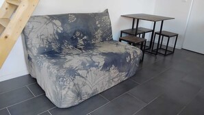Ein modernes Wohnzimmer mit einer Couch, einem kleinen Tisch und einer Treppe.