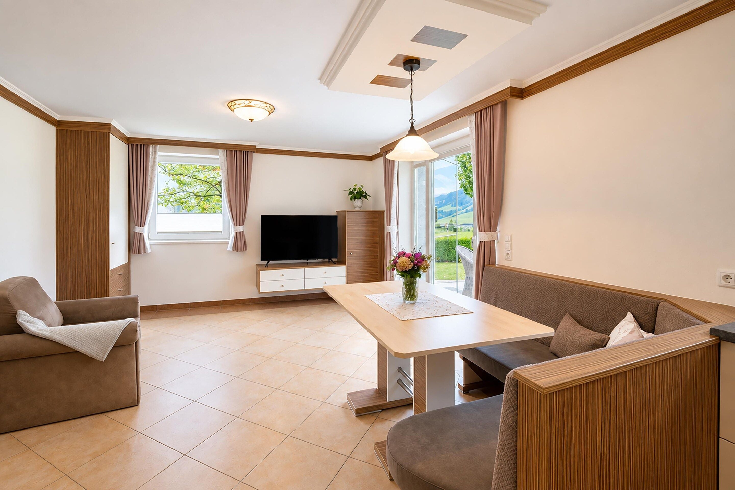 A modern living room with a sofa, a dining table, and a TV.