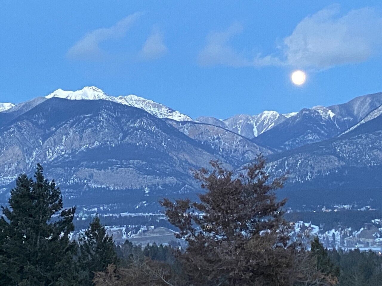 Paisatge de muntanyes amb cims nevats i un cel serè.