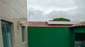 Ein Dachpool mit blauem Innenraum, umgeben von einer grünen Wand und einem gefliesten Dach.