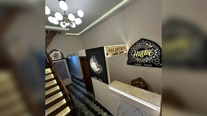 A reception area with a staircase, a reception desk, and signs indicating 'Good Vibes' and 'Casbah Hostel.' - Casbah Hostel (Algiers)