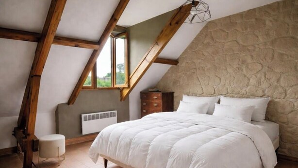 A bedroom with a sloped ceiling, a stone wall, a bed with white bedding, a wooden chair, and a window. - Chic House a 15 minutes of paris  (Argenteuil)