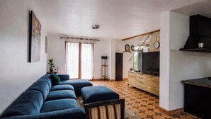 A living room with a sofa, a dining area with a table, and a kitchen with a stove. - Chic House a 15 minutes of paris  (Argenteuil)