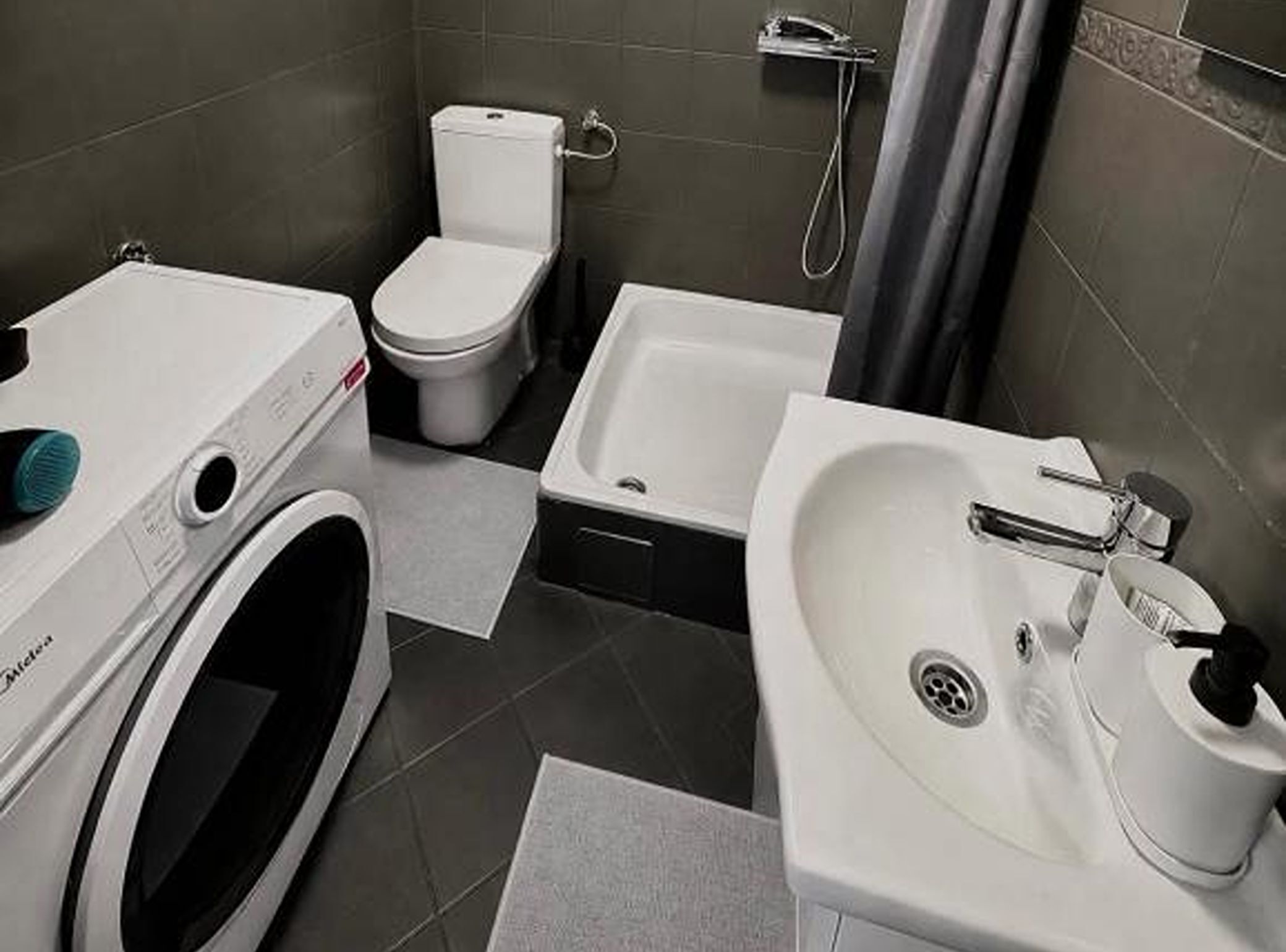 Un baño pequeño con inodoro, bidé, lavadora y lavabo.