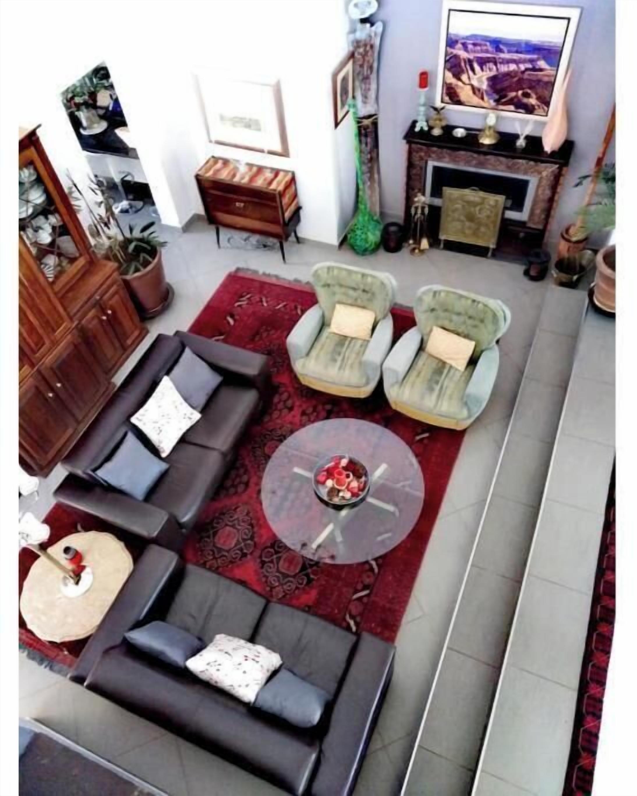 Un salon comprenant un canapé, deux fauteuils, une table basse et un téléviseur à écran plat.